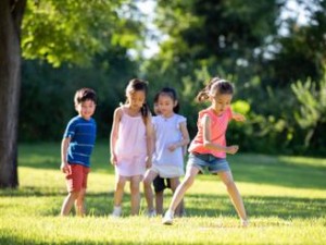 小孩和小孩一起草-草地上，两个小孩在愉快地玩耍